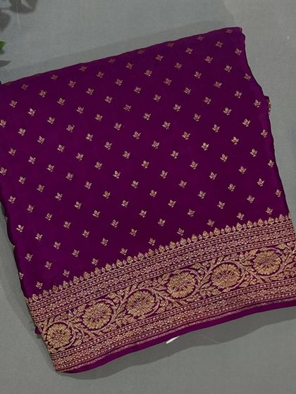 A beautiful Banarasi crepe saree in a rich purple with a detailed gold border.