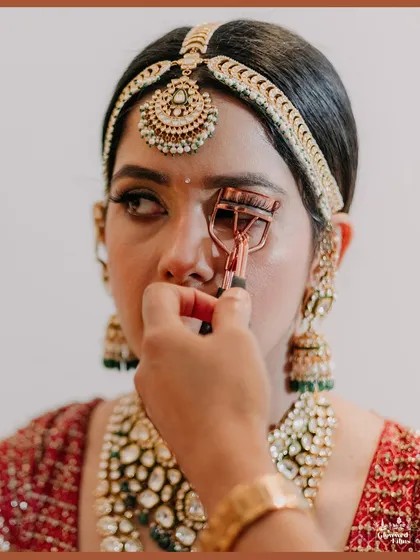 A close-up of the bride getting her makeup done, focusing on the precision and artistry of the bridal preparation process.