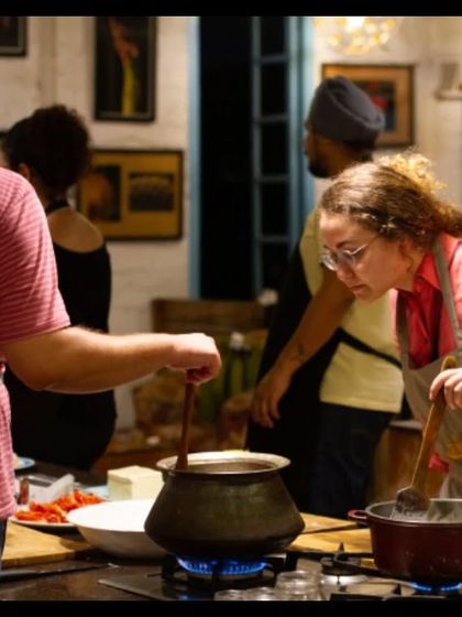 Two participants working together, stirring pots of fragrant curries. Our sessions are all about hands-on participation, ensuring everyone gets a real feel for the cooking process.