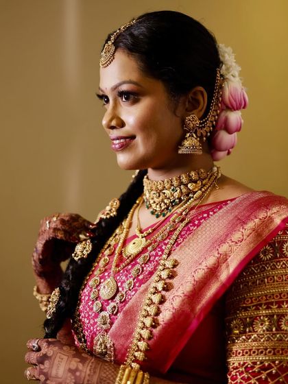 A side profile highlighting the intricate braid and floral arrangement, a hallmark of South Indian bridal beauty. The makeup is kept clean to let the traditional elements shine.