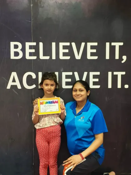 Posing in front of our "Believe It, Achieve It" wall, this student embodies our motto as she holds her new certificate.