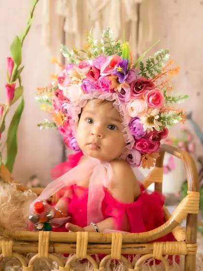Another variation of the half-birthday floral theme, this time with a vibrant pink dress and a stunning, oversized flower bonnet.