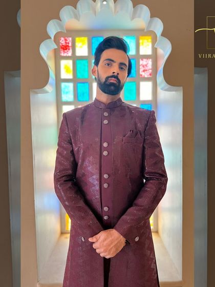 A deep maroon sherwani with a subtle texture, offering a sophisticated and colorful alternative to traditional groomswear.