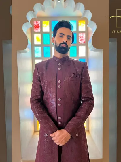 A groom wearing our custom maroon textured sherwani. This rich color is a fantastic choice for wedding ceremonies and receptions.