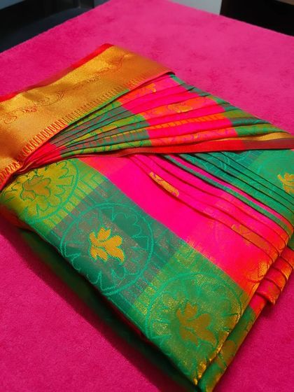 This image shows the box-folded saree from a top-down angle, with a clip holding the pleats in place.
