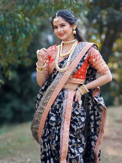 A different take on the Sankranti look, this black brocade Nauvari is paired with a vibrant red blouse and pearl jewellery.