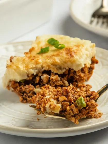 A close-up shot focusing on the texture of the plant-based shepherd's pie. This image is designed to show that vegan food can be just as hearty and appetizing as its traditional counterpart.