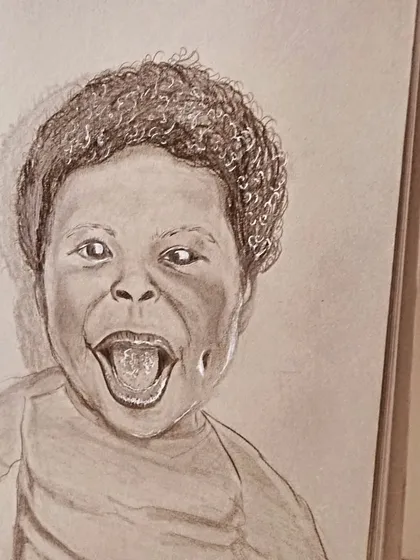 A joyful pencil portrait of a laughing child on a spiral-bound sketchbook. Capturing pure happiness in graphite is a magical process.