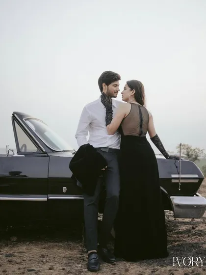 Elegance and intimacy define this moment from a vintage-themed shoot in Goa. Posed against a classic convertible, the couple shares a quiet look, captured in soft light to highlight their connection and the timeless glamour of the setting.