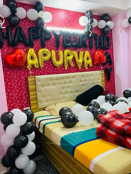 A closer look at the personalized birthday banner and balloon arrangement over the bed.