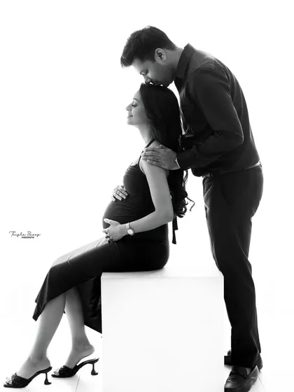 This black and white portrait emphasizes the tender connection between the couple. The simple, clean background keeps the focus entirely on their emotions.