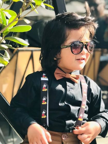 Adding a cool factor to the dapper kids' look with a pair of aviator sunglasses. It shows how accessories can completely change the attitude of an outfit.