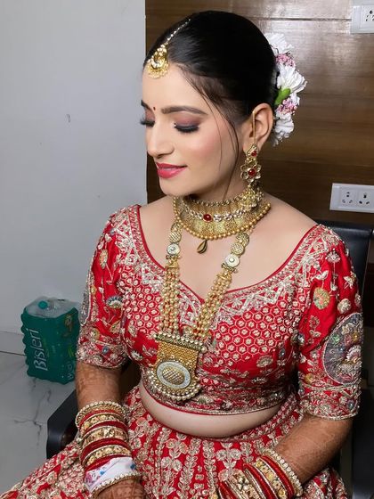 A side profile showing the elegant bridal bun adorned with flowers and the soft, blended makeup.