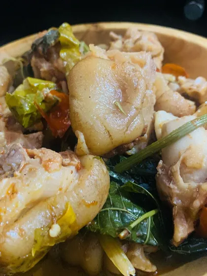 A bowl of tender pig trotters cooked with fresh herbs and chillies.