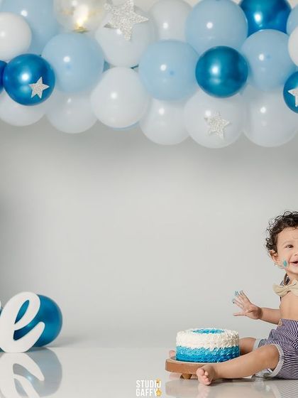 The full view of the beautiful blue and white balloon arch for a classic first birthday cake smash.
