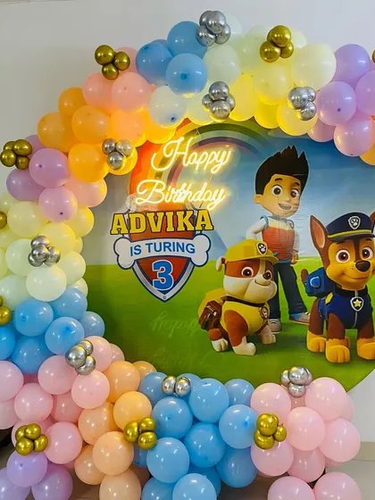 A fun Paw Patrol themed birthday for a 3-year-old. This decoration features a custom circular backdrop with the Paw Patrol characters and a colorful pastel balloon arch.