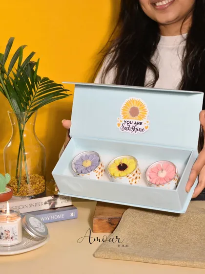 Brighten someone's day with The Sunshine Trio. This sunflower gift box includes three soy wax sunflower candles in jasmine, rose, and lavender fragrances.