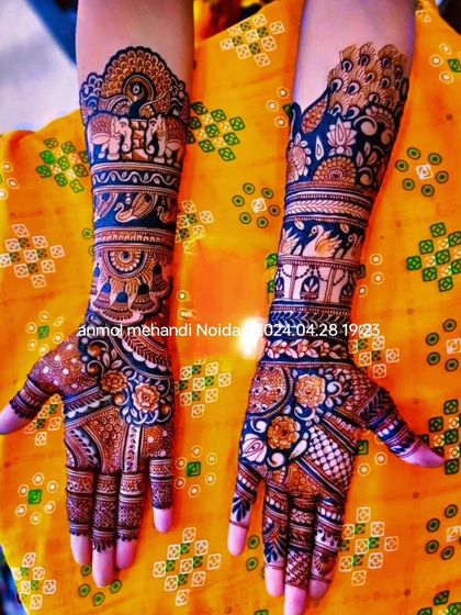 This design uses a striking blue-tinted henna to highlight the elephant and peacock motifs, creating a unique and modern twist on a classic style.
