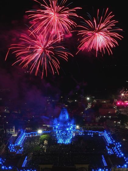 This aerial photo from a Janmashtami celebration in Chittorgarh captures the contrast between the serene, blue-lit temple and the explosive red fireworks, creating a powerful and memorable image.