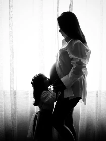 A creative take on maternity photography. This silhouette shot beautifully captures a mother's anticipation while including her older child in the moment. I love finding unique ways to tell your family's story.