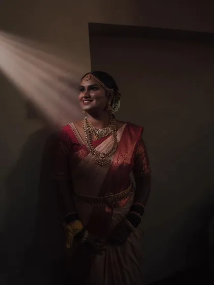 An artistic and moody bridal portrait using a single beam of light. This technique creates a dramatic and elegant photo that focuses on the bride's silhouette and expression.