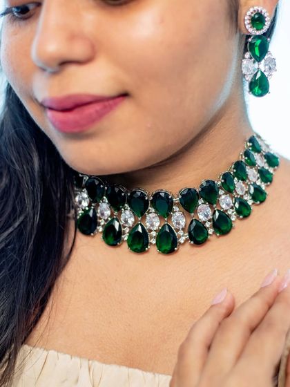 A close-up of a modern choker made with large emerald-green and white stones. A bold and glamorous choice.