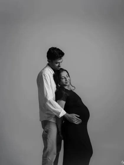 A quiet, intimate embrace captured in a black and white portrait. This image focuses on the emotional connection and the feeling of safety and love between the couple.