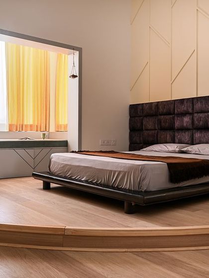 This bedroom features a unique circular wooden platform to elevate the bed, creating a distinct zone within the room. I also enclosed the balcony to create a spacious window seat and study area.