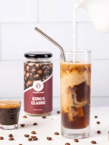A refreshing glass of iced coffee, with milk being poured in. I used a special technique to create realistic, long-lasting condensation on the glass, which is essential for cold drink photography.