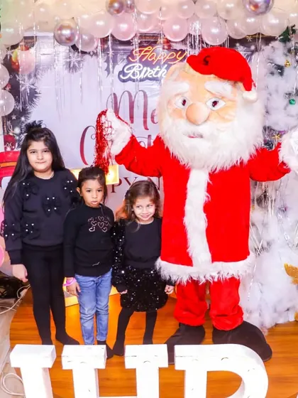 Themed birthday parties are one of our specialties. This photo from a Christmas-themed celebration shows the pure delight of children meeting a friendly Santa Claus mascot right here at our venue.
