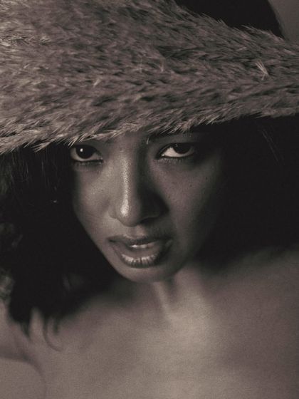 A strong, confrontational gaze from below. This angle, combined with the dramatic shadows of the black and white treatment, creates a powerful and commanding portrait.