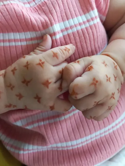 How sweet are these little hands? I applied a simple pattern of tiny four-petaled flowers, which is a great option for very young children who can't sit still for long.
