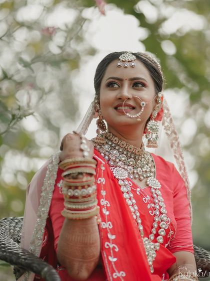 A beautiful outdoor bridal portrait. The bride's elaborate jewelry and serene expression are captured perfectly in the soft, natural light.