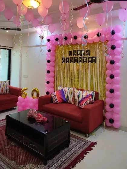 A 60th birthday celebration with a simple and elegant pink and black theme. A rectangular balloon frame surrounds a gold shimmer curtain, creating a classic photo backdrop.