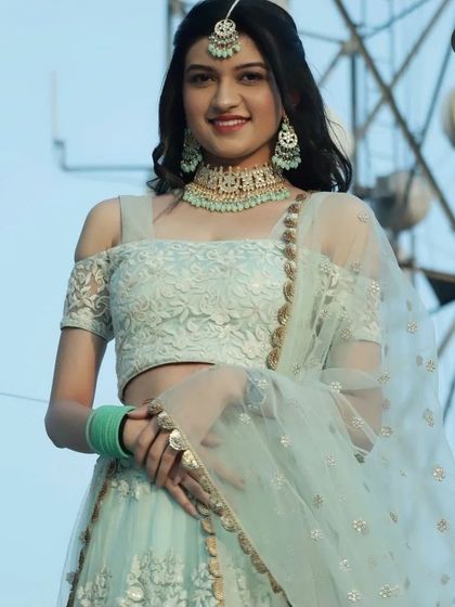 A smiling shot of our client in the mint green rental lehenga. It's a lightweight, comfortable, and stylish option for dancing the night away.