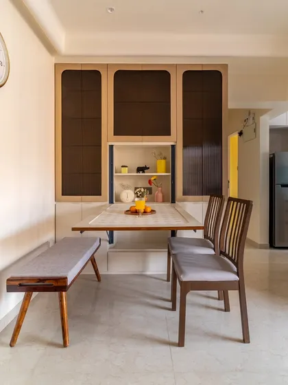 In Mumbai, furniture must work hard. This custom-designed dining unit features a wall-mounted folding table and a sleek bench, providing a complete dining solution that can be neatly tucked away to maximize living space.