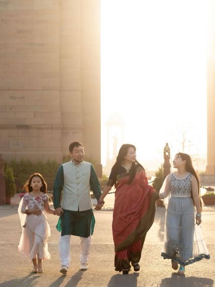 A family of four walks hand-in-hand against the iconic backdrop of India Gate at sunset. Outdoor shoots allow us to create stunning, cinematic portraits.