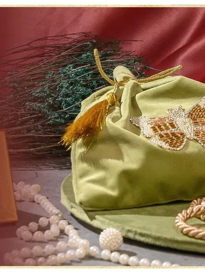 Introducing my 'Ibtidaa' wedding collection. This image showcases one of the beautiful elements, a soft velvet potli bag with a hand-beaded butterfly motif, perfect for holding precious gifts.