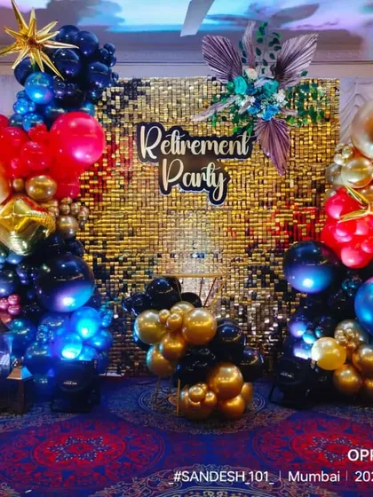 A grand and colorful retirement party backdrop. The gold sequin wall is framed by a vibrant balloon arrangement, celebrating a major life milestone in style.