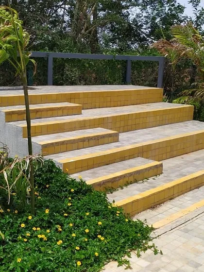 Bright yellow tiles add a vibrant pop of color to this stepped seating area. This detail transforms a functional set of stairs into a cheerful and inviting landscape feature.