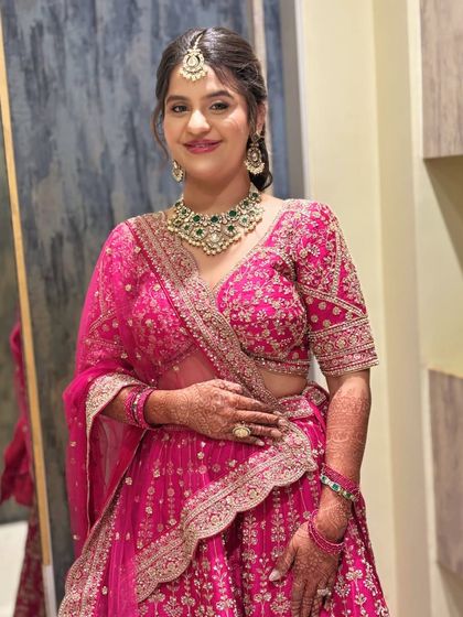 A full-length shot of the bride, looking radiant and happy. The pink lehenga and soft glam makeup are a perfect combination.