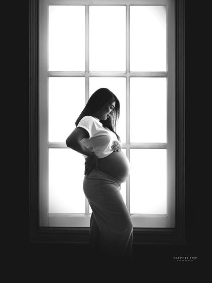 A classic window silhouette in black and white. This timeless technique creates a beautiful and intimate portrait, focusing on the shape and form of the mother-to-be.