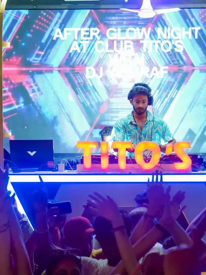 The view from the dance floor during my "After Glow Night" set. The crowd's hands are up, fully immersed in the music and the vibrant visuals of the stage setup.