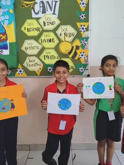 Students hold up their colorful posters, each with a unique message about saving the Earth, during our school-wide competition.
