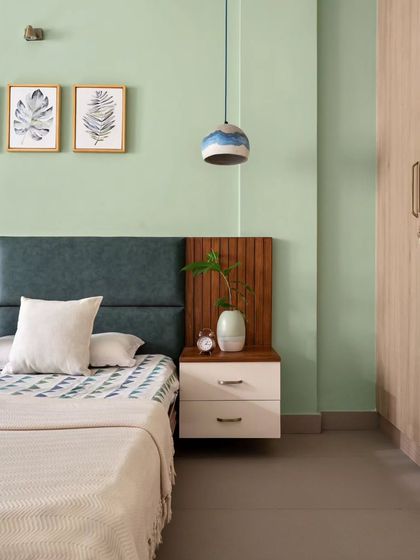A detail shot of the guest bedroom, highlighting the custom headboard combining forest green upholstery with fluted wood paneling, creating a serene and stylish retreat.