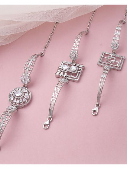 A collection of three distinct silver bracelets. Each piece features a unique central charm and link design, showcasing the variety and style of our collection.