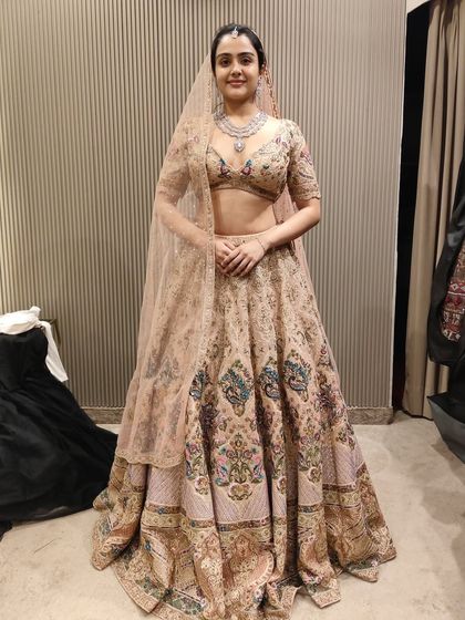 A happy client during her trial in a beautiful pastel peach lehenga with floral embroidery. It’s a perfect look for a day wedding or engagement.
