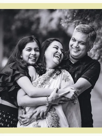 A candid black and white portrait of a family sharing a genuine, heartfelt laugh. This is the essence of our lifestyle photography approach, capturing the real connections and happy moments.