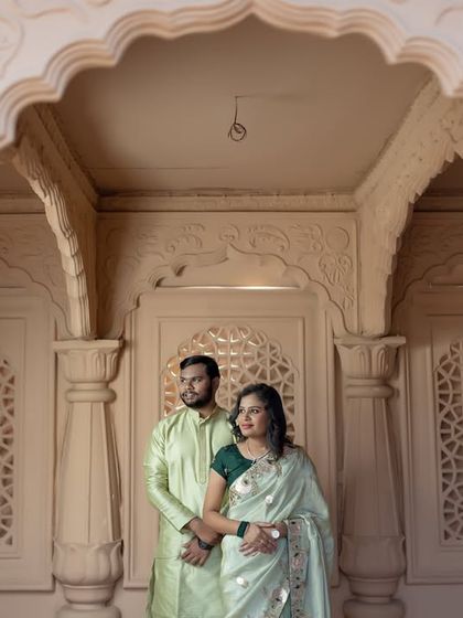 A beautifully composed shot using the pillars and archways of a palace to frame the couple, creating a sense of grandeur and elegance.