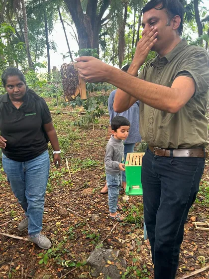 An adult participant smells a part of the beehive, engaging his senses to learn more about the bees' world.